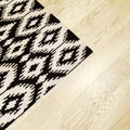 Rug with ethnic design on wooden floor