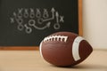 Rugby ball near chalkboard with football game scheme