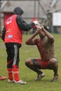 Rugby player cleaning the mud of his face