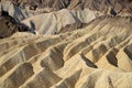 Barren, colorful desert landscape of sharp, steep ridges, mountains, gullies, and canyons