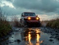 rugged car splashes through a muddy trail at sunset Royalty Free Stock Photo