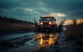 rugged car splashes through a muddy trail at sunset Royalty Free Stock Photo