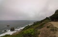 Rugged cliffs and Golden Gate Bridge covered with fog in San Francisco seen from the Lands End trail Royalty Free Stock Photo