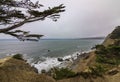 Rugged cliffs and Golden Gate Bridge covered with fog in San Francisco seen from the Lands End trail Royalty Free Stock Photo