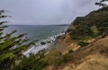 Rugged cliffs and Golden Gate Bridge covered with fog in San Francisco seen from the Lands End trail Royalty Free Stock Photo