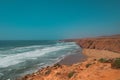 Rugged cliffside view of Aftas Beach and Atlantic Ocean in the chill coastal town of Mirleft, Morocco.