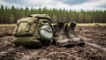 Rugged hiking gear with olive backpack and muddy boots in forest clearing on overcast day Royalty Free Stock Photo