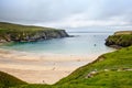 Rugged landscape at Malin Head, County Donegal, Ireland. Beach with cliffs, green rocky land with sheep on foggy cloudy Royalty Free Stock Photo