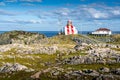 Rugged Newfoundland coastline with red and white striped lighthouse at Cape Bonavista Canada Royalty Free Stock Photo