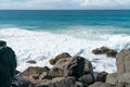 Rugged rocky waters edges with sea surging in and view to horizon