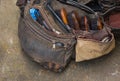 Rugged and torn leather bag of a cobbler containing shoe polish brush and tools. Royalty Free Stock Photo