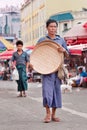 Traditional dressed manwalks on a market place in Ruili, Yunnan Province, China