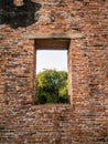 Ruin and ancient orange brick wall with a window view to the trees