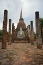 Ruin of Buddha sitting in front of a pagoda wiht stone pillars