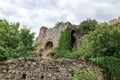 Ruin of medieval stone house surrounded by green trees in abandoned byzantine city Mystras, Greece