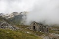 Ruin of old refuge in clouds. Monte Rosa massif near Punta Indren. Alagna Valsesia area,