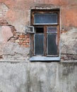 Ruined and abandoned house exterior. Abandoned house. Broken glass in the window and falling plaster Royalty Free Stock Photo