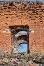 A ruined ancient Christian church made of red brick in summer in the daytime against a blue sky. Royalty Free Stock Photo