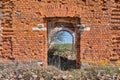 A ruined ancient Christian church made of red brick in summer in the daytime against a blue sky. Royalty Free Stock Photo