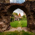 Ruined brick archway inside medieval Slimnic citadel in Romania