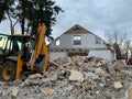 Ruined, brick, residential building. The ruins of a collapsed mansion in the forest. Demolition of an old house with an excavator Royalty Free Stock Photo