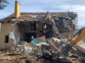 Ruined, brick, residential building. The ruins of a collapsed mansion in the forest. Demolition of an old house with an excavator Royalty Free Stock Photo