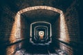 Ruined brick underground tunnel or corridor and light in end, abstract way to hope or escape to freedom Royalty Free Stock Photo