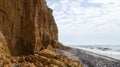 Ruined clay slope by the sea. Cracked clay cliff on the coast.