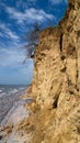 Ruined clay slope by the sea. Cracked clay cliff on the coast.