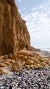 Ruined clay slope by the sea. Cracked clay cliff on the coast.