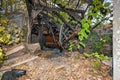 Ruined and collapsed house burnt and damaged in the fire with remains of the wooden reinforcement poles of roof selective focus