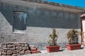 A ruined concrete building with a bricked-up window next to some bricks and plants in the courtyard Marche, Italy Royalty Free Stock Photo