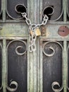 cadena y cerrajaa ruined green metal and glass door with broken glass panes and a chain with a padlock coming out of one of the Royalty Free Stock Photo