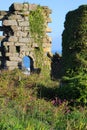 Ruined wall with archway on clifftop at derelict copper mine at Treen Cove on north coast of Cornwall, England