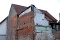 Ruined house with empty windows, broken brick, cracks on the wall of a dilapidated building, the concept of ruin of people,