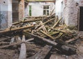 Ruined interior of old abandoned building. wooden logs of broken roof