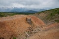 A ruined large log mine high in the mountains. Extraction of minerals in the highlands. The rock is red and orange.