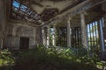 Ruined mansion hall interior overgrown by plants. Nature and abandoned architecture, green post-apocalyptic concept