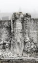 Ruined stone statue on cemetery tombstone