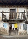 a ruined village house with a wooden balcony, with a clothesline, laundry in a rural environment, concept of depopulation of rural Royalty Free Stock Photo
