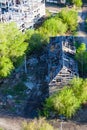 Ruined wooden house on the background of the erection of a new building - renovation program. Demolition of low-rise buildings Royalty Free Stock Photo