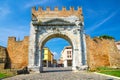 Ruins of ancient brick wall and stone gate Arch of Augustus Arco di Augusto and cobblestone road in old historical city Rimini