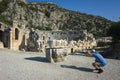 Ruins of ancient city of Myra in Demre, Turkey. Man tourist taking photo of theatrical mask relief Royalty Free Stock Photo