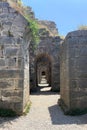 Ruins ancient city stone temple in ?zmir, top arches, keystones, columns, torso statue, high stone wall