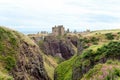 Ruins of ancient Dunnottar castle in green scottish hills. Royalty Free Stock Photo