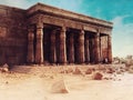 Ruins of an ancient Egyptian temple including a wall, columns and stone statues Royalty Free Stock Photo