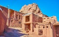 The ruins of ancient fort behind the medieval adobe houses in hilly street of Abyaneh village Royalty Free Stock Photo