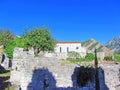 The ruins of an ancient fortress. old thick stone walls of a European fortress overgrown with greenery in the mountains. Doors and Royalty Free Stock Photo