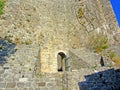 The ruins of an ancient fortress. old thick stone walls of a European fortress overgrown with greenery in the mountains. Doors and Royalty Free Stock Photo