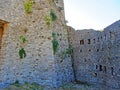 The ruins of an ancient fortress. old thick stone walls of a European fortress overgrown with greenery in the mountains. Doors and Royalty Free Stock Photo